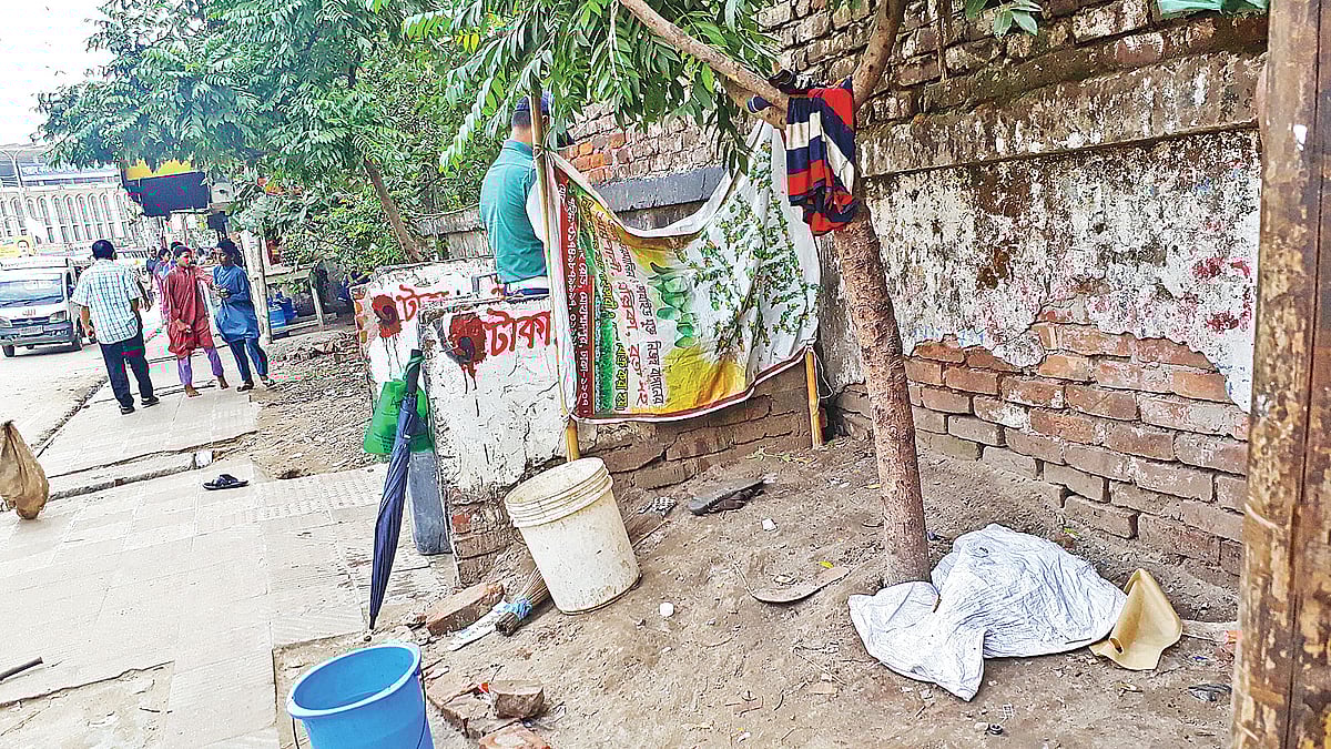 মোহাম্মদপুরে ফুটপাতে বানানো হয়েছে প্রস্রাবখানা। গত মঙ্গলবার একজনকে দেখা গেল এ প্রস্রাবখানা ব্যবহার করতে। ছবি: প্রথম আলো