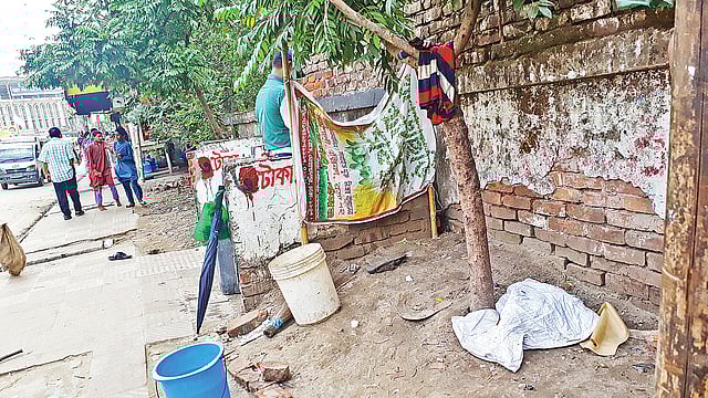 মোহাম্মদপুরে ফুটপাতে বানানো হয়েছে প্রস্রাবখানা। গত মঙ্গলবার একজনকে দেখা গেল এ প্রস্রাবখানা ব্যবহার করতে।  ছবি: প্রথম আলো