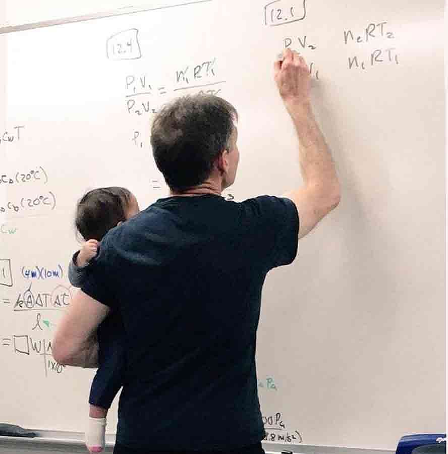 ছাত্রীর মেয়েকে কোলে নিয়ে এভাবেই ক্লাসে পড়াচ্ছিলেন পদার্থবিজ্ঞানের অধ্যাপক ব্রুস জনসন। ছবি: সংগৃহীত