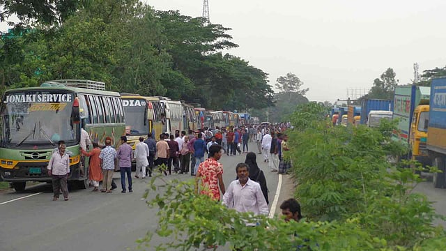 যানজটে বসে থাকতে থাকতে গাড়ি থেকে বের হয়ে রাস্তায় নেমে আসে যাত্রীরা। মিরসরাই, ১১ মে। ছবি: ইকবাল হোসেন