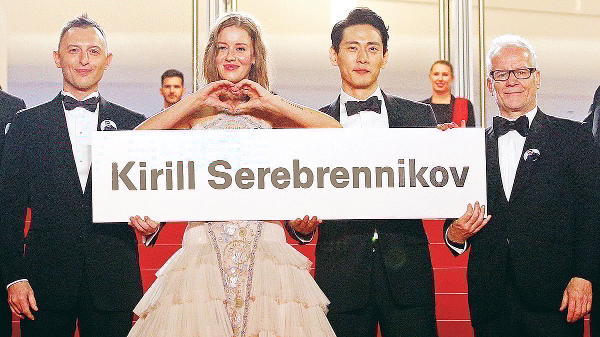 লেতোর প্রদর্শনীর আগে নির্মাতা কিরিল সেরেব্রেন্নিকভের নামের প্ল্যাকার্ড হাতে লালগালিচায় উৎসব–পরিচালক থিয়েরি ফ্রেমোর (ডানে) সঙ্গে ছবির শিল্পীরা। গত বুধবার, কানে।  রয়টার্স