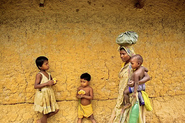 খেত থেকে ফিরছেন এক মা, কোলে সন্তান। নওগাঁ। ছবি: সুমন ইউসুফ