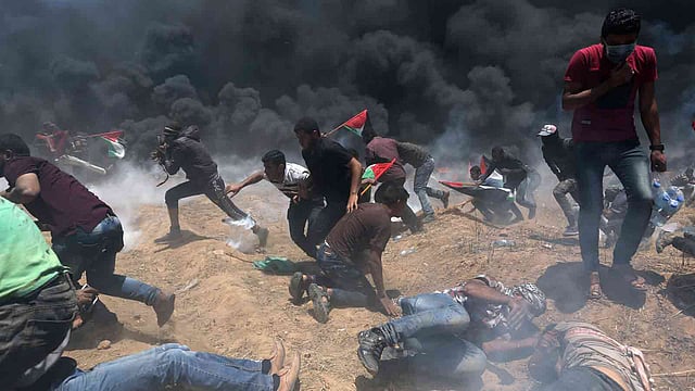 জেরুজালেমে মার্কিন দূতাবাস খোলার প্রতিবাদে বিক্ষুব্ধ ফিলিস্তিনিদের লক্ষ্য করে গুলি ও কাঁদানে গ্যাসের শেল ছোড়ে ইসরায়েলি সেনাবাহিনী। গাজা, ১৪ মে। ছবি: রয়টার্স