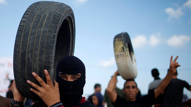 টায়ার পুড়িয়ে বিক্ষোভ করছেন ফিলিস্তিনি আন্দোলনকারীরা। ছবি: রয়টার্স