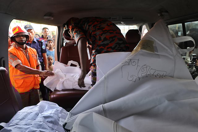 পিষ্ট হয়ে নিহতদের লাশ নিয়ে যাওয়া হচ্ছে। ছবি: প্রথম আলো