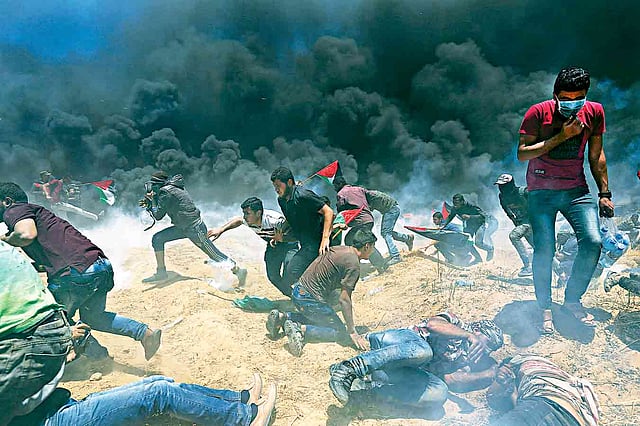 ইসরায়েল রাষ্ট্র প্রতিষ্ঠার দিন নাকাবা দিবস (ফিলিস্তিনিদের জন্য মহাবিপর্যয় দিন) উপলক্ষে এবং জেরুজালেমে যুক্তরাষ্ট্রের দূতাবাস স্থানান্তরের প্রতিবাদে ডাকা ফিলিস্তিনিদের বিক্ষোভে গুলি ও কাঁদানে গ্যাস ছোড়ে ইসরায়েলের নিরাপত্তা বাহিনী। গতকাল গাজা উপত্যকার দক্ষিণাঞ্চলে ইসরায়েল-গাজা সীমান্তে।  ছবি: রয়টার্স