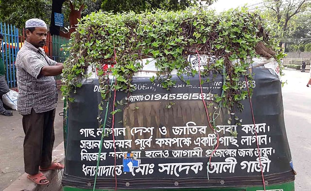 গাছ ভালোবাসেন সিএনজি চালিত অটোরিকশাচালক মো. সাদেক আলী গাজী৷ নিজের অটোরিকশার ছাদে লাগিয়েছেন লতানো উদ্ভিদ। শাহবাগ, ঢাকা, ১৮ মে। ছবি: সুমন ইউসুফ