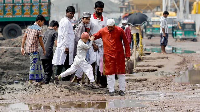 বৃষ্টির পানি জমে আছে খানাখন্দে ভরা সড়কে। জুমার নামাজ শেষে বাড়ি ফিরতে বিড়ম্বনায় মুসল্লিরা। জুরাইন, শ্যামপুর, ঢাকা, ১৮ মে। ছবি: দীপু মালাকার