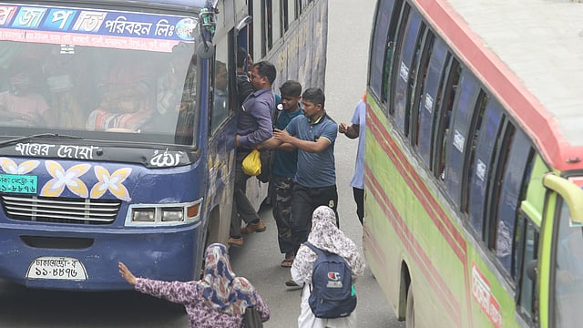 দুই বাসের মাঝখান দিয়ে বাসে উঠছেন যাত্রীরা।