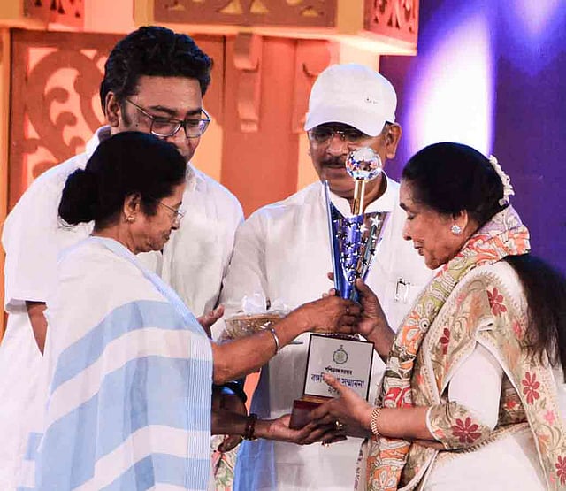 আশা ভোঁসলের হাতে ‘বঙ্গবিভূষণ’ সম্মাননা তুলে দেন পশ্চিমবঙ্গের মুখ্যমন্ত্রী মমতা বন্দ্যোপাধ্যায়। ছবি: ভাস্কর মুখার্জি