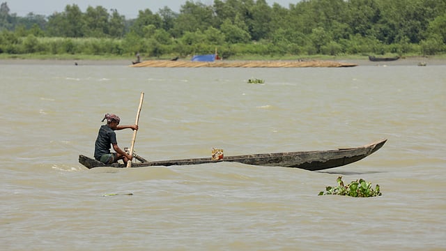 পোনা ধরতে নদীর অন্য প্রান্তে যাচ্ছেন একজন।
