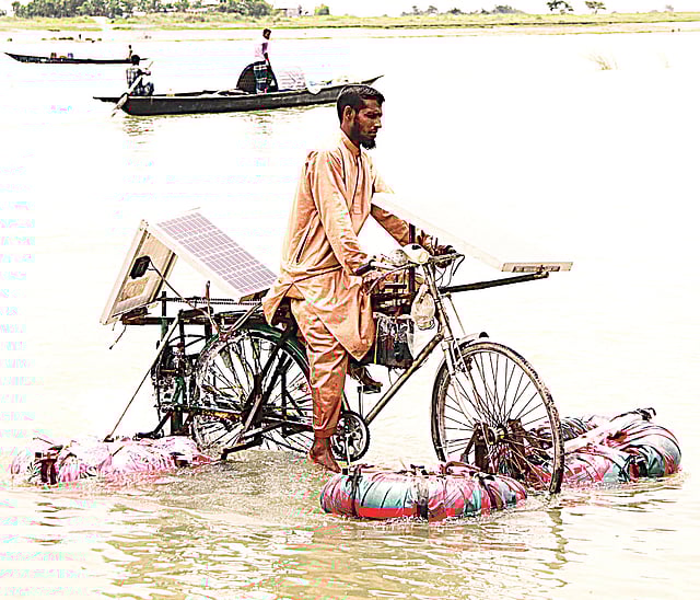 সাইকেলের চাকার দুই পাশে বাতাসভর্তি টিউব থাকায় সহজে ভারসাম্য রক্ষা হয়। গত মঙ্গলবার ফরিদপুর সদর উপজেলার ধলার মোড় এলাকায় পদ্মা নদীতে।  ছবি: প্রথম আলো