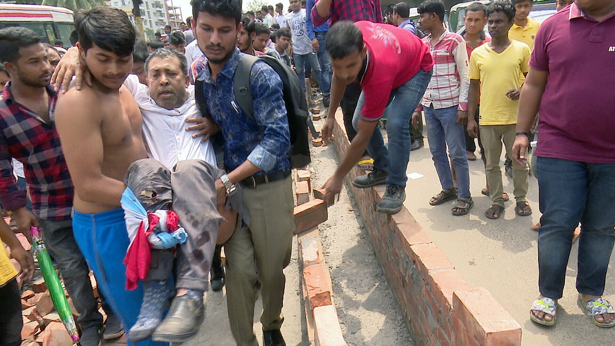 মহাখালীতে বাসের চাপা থেকে উদ্ধার করে নুরুল আমিনকে হাসপাতালে নেওয়া হচ্ছে (ফাইল ছবি)