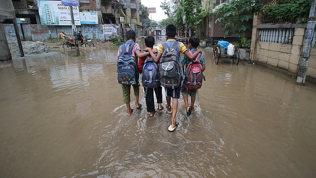 জমে থাকা পানি মাড়িয়ে কোচিং সেন্টার থেকে ফিরছে শিশুরা। দক্ষিণ বনশ্রী, খিলগাঁও, ঢাকা। ছবি: আবদুস সালাম
