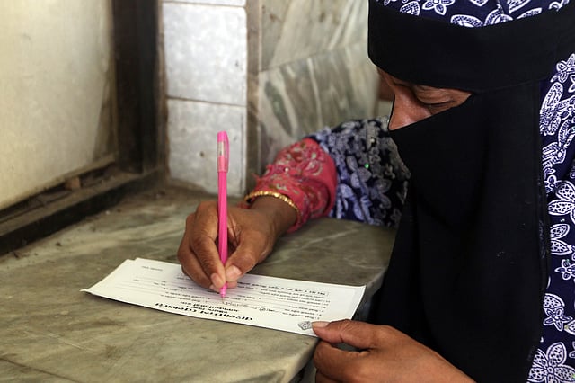 টিকিট নিতে নির্ধারিত ফর্মে নাম লিখছেন এই নারী। সকাল সাড়ে আটটা। চট্টগ্রাম রেলস্টেশন, চট্টগ্রাম, ১ জুন। ছবি: জুয়েল শীল