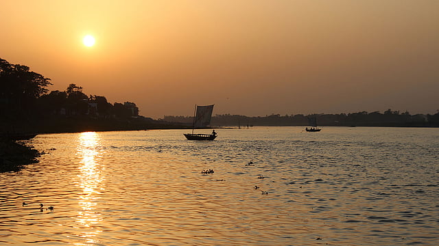 সারা দিন ঝরেছে বৃষ্টি। পশ্চিম আকাশ রাঙিয়ে ব্রহ্মপুত্র নদের ওপারে অস্ত যাচ্ছে সূর্য। অপরূপ এই সৌন্দর্য উপভোগ করতে খেয়া নৌকায় ভাসছে মানুষ। জয়নুল আবেদীন পার্ক, ব্রহ্মপুত্র নদ, ময়মনসিংহ, ১ জুন। ছবি: আনোয়ার হোসেন