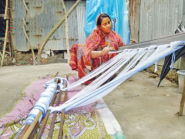 রুহিতপুরের জমিলা লুঙ্গি বুনছেন।  ছবি: প্রথম আলো