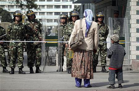 উরুমচির পিপলস স্কয়ারে ঢোকার আগে নিরাপত্তা বাহিনীর অনুমোদন নিতে হচ্ছে নারীকে। ২০০৯ সালের সেপ্টেম্বরে তোলা। ছবি: রয়টার্স
