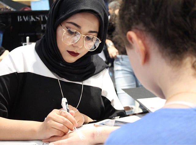 মেহেদিতে এক নারীর হাত রাঙিয়ে দিচ্ছেন সামিয়া হাসানাত। ছবি: সংগৃহীত