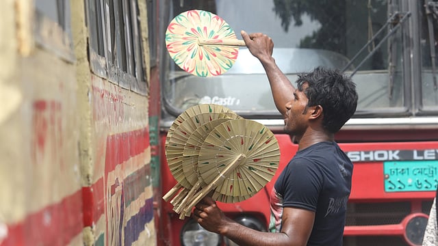 তীব্র গরমে অতিষ্ঠ মানুষ। তাই বেড়েছে হাতপাখার চাহিদা। হাতপাখা ফেরি করে বেড়াচ্ছেন এক হকার। শাহবাগ মোড় এলাকা, ঢাকা, ১০ জুন। ছবি: আবদুস সালাম