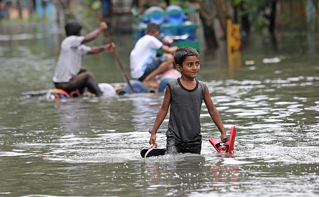 বৃষ্টির পানিতে বড়দের দুর্ভোগ পোহাতে হলেও এই শিশুকে বেশ খুশি মনে হচ্ছে। আগ্রাবাদ সিডিএ এলাকা, চট্টগ্রাম, ১১ জুন। ছবি: জুয়েল শীল
