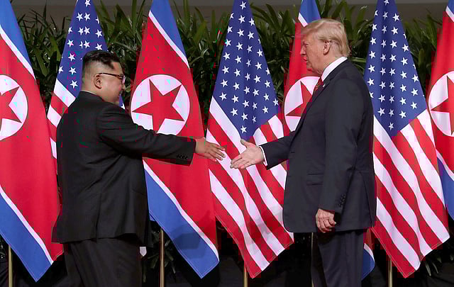 করমর্দন করছেন ডোনাল্ড ট্রাম্প ও কিম জং-উন। এই করমর্দনকে ঐতিহাসিক হিসেবে বিবেচনা করা হচ্ছে।