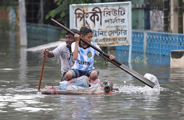 বৃষ্টির পানিতে বাঁশের টুকরো দিয়ে ভেলা বানিয়ে চড়ে বেড়াচ্ছে দুই কিশোর। আগ্রাবাদ সিডিএ এলাকা, চট্টগ্রাম, ১১ জুন। ছবি: জুয়েল শীল