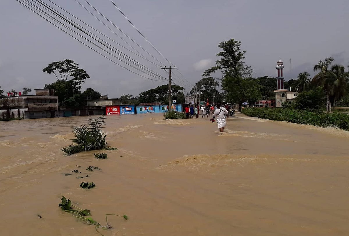 মৌলভীবাজার-কুলাউড়া সড়কের রাজনগরের কদমহাটা এলাকায় বন্যার পানি প্রবাহিত হচ্ছে। গতকাল শুক্রবার বিকেলে মনু নদ প্রকল্পের বাঁধ ভেঙে এই পানি প্রবেশ করছে। মৌলভীবাজার, ১৬ জুন। ছবি: প্রথম আলো
