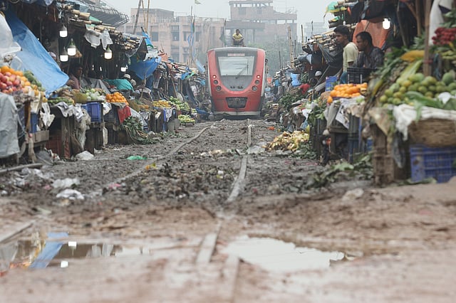 দুই পাশের বাজারের মধ্য দিয়ে ধেয়ে আসছে ট্রেন।