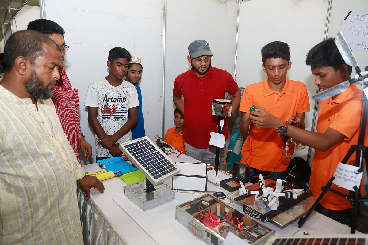 একটি স্টলে আগত দর্শনার্থীদের কাছে খুদে দুই শিক্ষার্থী নিজেদের উদ্ভাবন সম্পর্কে বিস্তারিত তথ্য তুলে ধরছে। জাতীয় বিজ্ঞান ও প্রযুক্তি জাদুঘর, আগারগাঁও, ঢাকা, ২৪ জুন। ছবি: প্রথম আলো