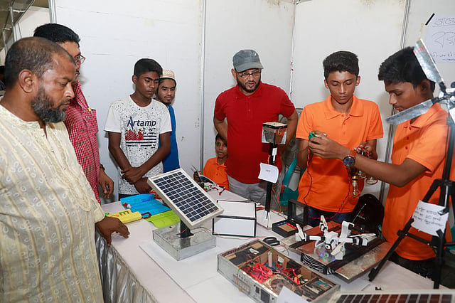 একটি স্টলে আগত দর্শনার্থীদের কাছে খুদে দুই শিক্ষার্থী নিজেদের উদ্ভাবন সম্পর্কে বিস্তারিত তথ্য তুলে ধরছে। জাতীয় বিজ্ঞান ও প্রযুক্তি জাদুঘর, আগারগাঁও, ঢাকা, ২৪ জুন। ছবি: প্রথম আলো