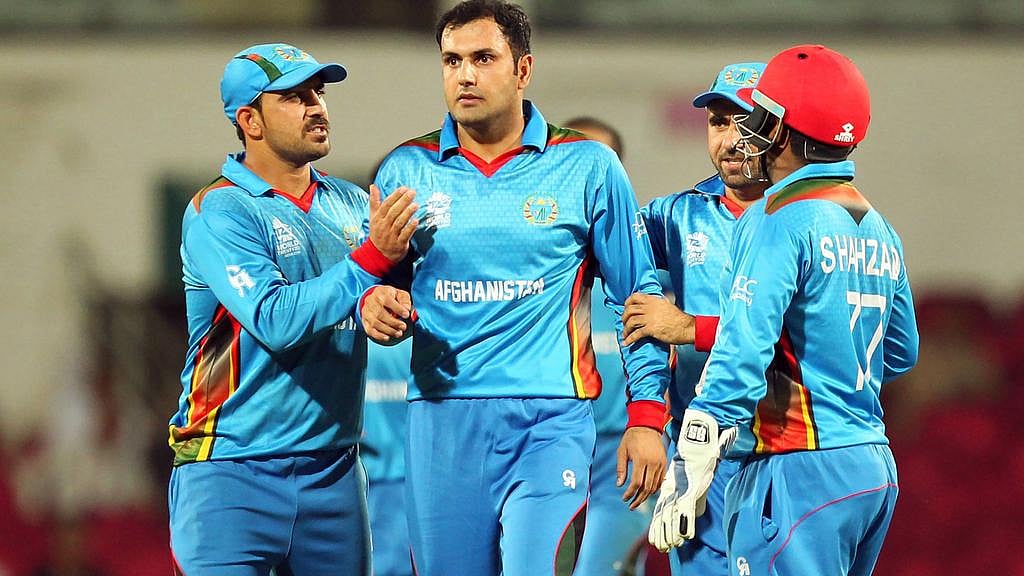 সাদা পোশাকে খেলতে নামার অনেক আগেই রঙিন পোশাকে ক্রিকেট বিশ্বে চমক দেখিয়েছে আফগানিস্তান। ছবি: এএফপি