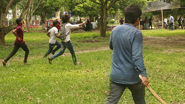 আমবাগানে দেশীয় অস্ত্র নিয়ে ছুটে যায় হামলাকারীরা। ছবি: শহীদুল ইসলাম