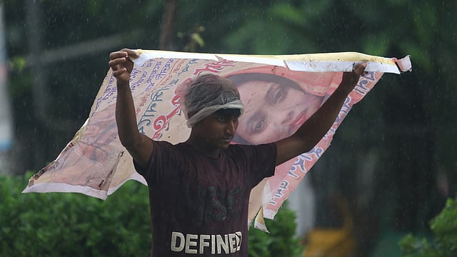 সেদিন গুঁড়ি গুঁড়ি বৃষ্টি হয়েছে। বিকেলে ভারী বৃষ্টি নামে। বৃষ্টির ছাঁট থেকে বাঁচার চেষ্টা এক তরুণের। রাজু ভাস্কর্য এলাকা, ঢাকা বিশ্ববিদ্যালয়, ২৬ জুলাই। ছবি: আবদুস সালাম