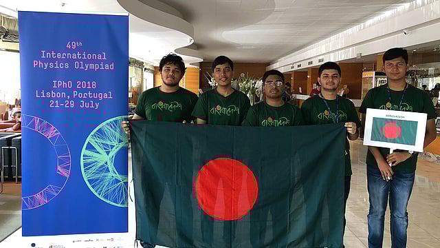 বাংলাদেশের পতাকা হাতে ফিজিকস অলিম্পিয়াডে ব্রোঞ্জ-জয়ী চারজন। বাঁ থেকে আবরার আল শাদীদ আবীর, তাহমিদ মোসাদ্দেক, ইরতিজা ইরাম, রাশেদুল ইসলাম। পাশে দলের অপর সদস্য ইমতিয়াজ তানভীর রাহিম। ছবি: সংগৃহীত