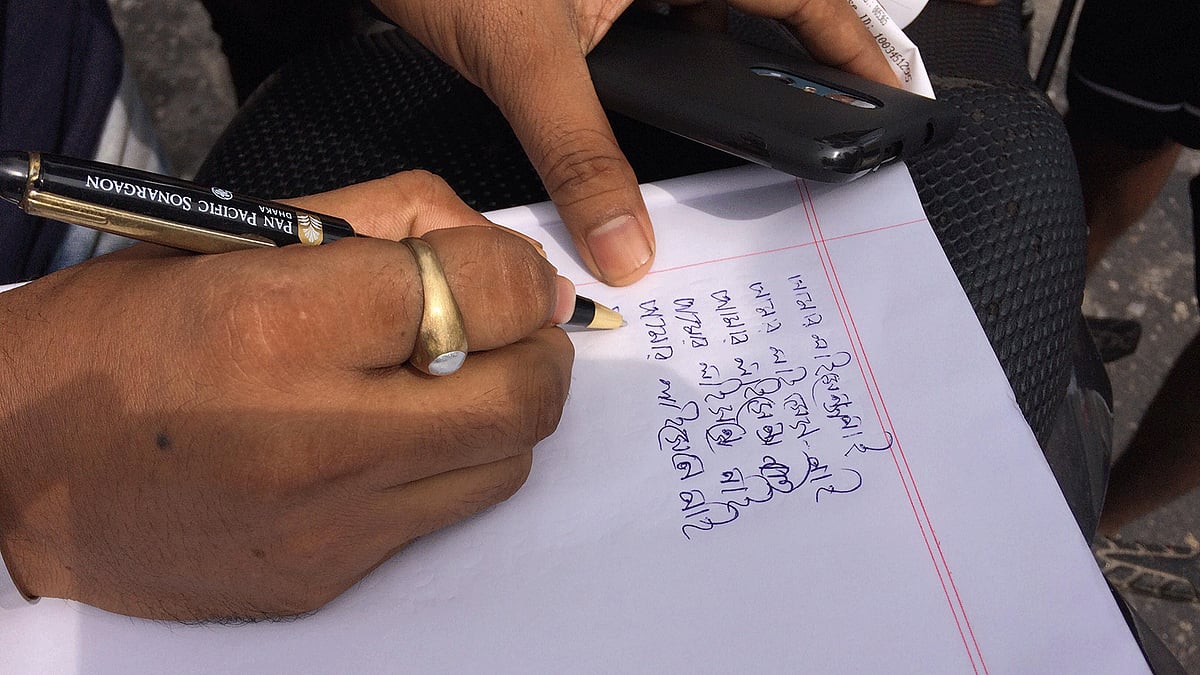 এক মোটরসাইকেল আরোহী সাদা খাতায় ১০ বার লিখতে বাধ্য হয়েছেন- ‘আমার লাইসেন্স নাই’। আসাদগেট সিগন্যাল, ঢাকা, ২ আগস্ট। ছবি: প্রথম আলো