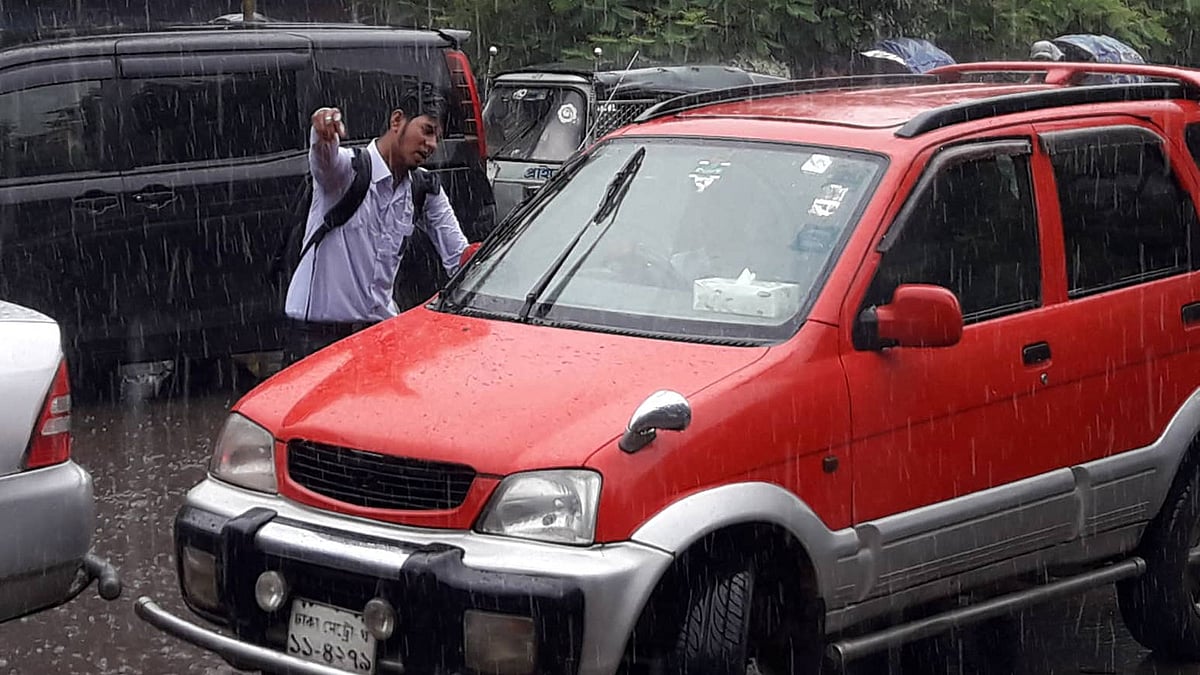সায়েন্স ল্যাবরেটরি ও নিউমার্কেট এলাকায় বিভিন্ন গাড়ির চালকের লাইসেন্স আছে কি না, তা পরীক্ষা করে দেখছে এক শিক্ষার্থী। এ সময় ওই এলাকায় বৃষ্টি হতে থাকে। ছবি: মোছাব্বের হোসেন।