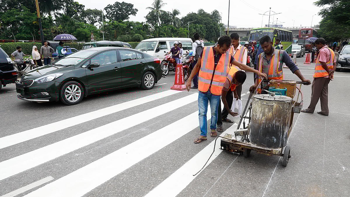 শহীদ রমিজ উদ্দিন ক্যান্টনমেন্ট স্কুল অ্যান্ড কলেজের সামনের সড়কে সিটি করপোরেশনের উদ্যোগে চলছে জেব্রা ক্রসিং ও গতিরোধক হাম্প তৈরির কাজ। গতকালের ছবি।  প্রথম আলো
