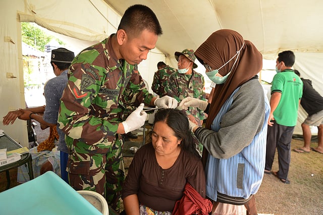 আহত এক নারীকে চিকিৎসা সেবা দেওয়া হচ্ছে। লাপানগান, তানজুং, ইন্দোনেশিয়া, ৮ আগস্ট। ছবি: এএফপি