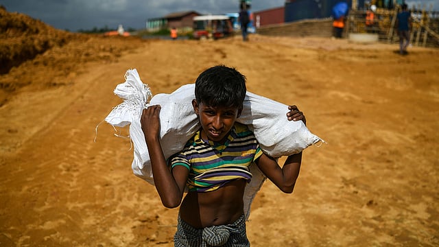 বস্তা নিয়ে হাঁটছে এক বালক। গত মঙ্গলবার উখিয়ার কুতুপালং আশ্রয়শিবিরে।  এএফপি