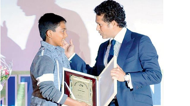 ২০১৩ সালের ছবি। পৃথিবীকে তার ৫৪৬ রানের ইনিংসের জন্য সংবর্ধিত করছেন টেন্ডুলকার। ফাইল ছবি