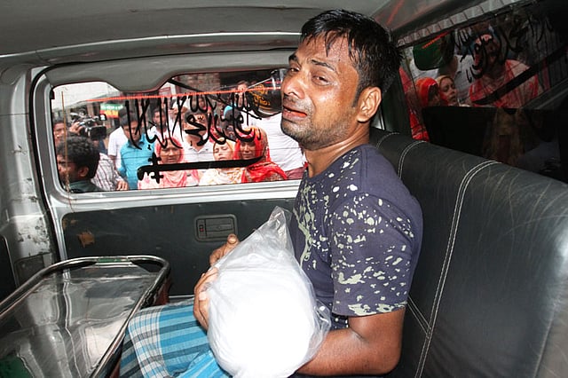 হারুন অর রশীদের কোলে কাফনে মোড়ানো নিথর আকিফা—একজন বাবার হাতে দুনিয়ার সবচেয়ে দুর্বহ বোঝা। ঢামেক, ৩০ আগস্ট। ছবি: দীপু মালাকার