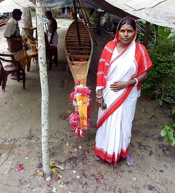 নিজের নৌকার সঙ্গে পুতুল মজুমদার। ছবি: প্রথম আলো