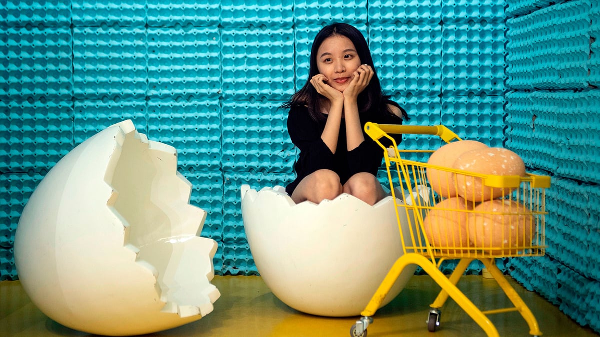 ডিমের বাড়িতে ডিমের খোসায় বসে ছবি তুলছেন এক তরুণী। গত শুক্রবার চীনের সাংহাইয়ে। এএফপি