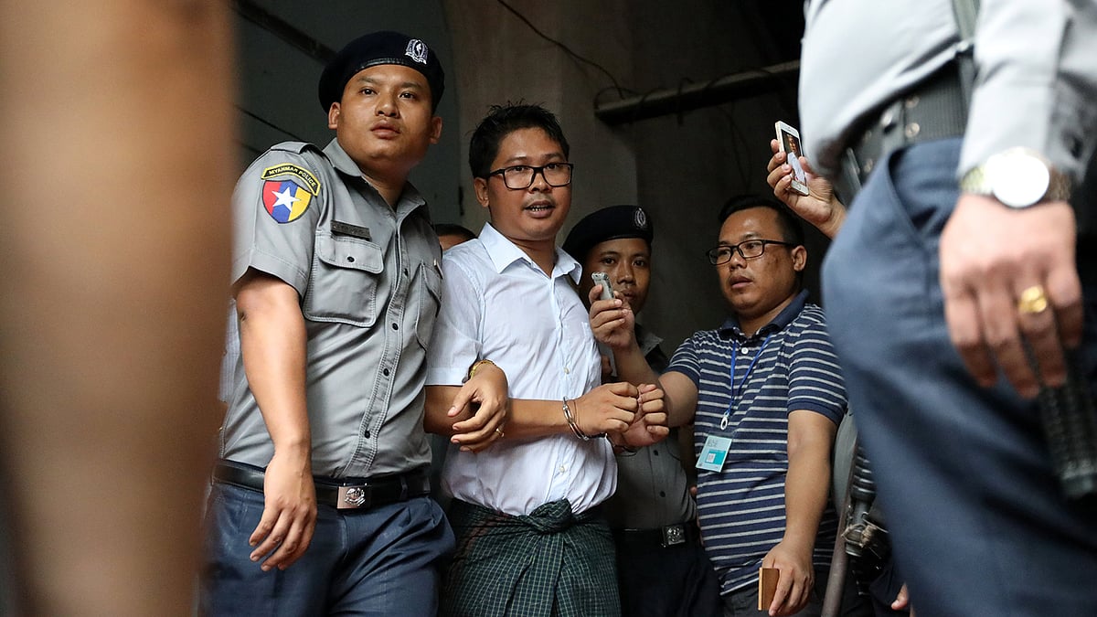 রায় ঘোষণার পর আদালত থেকে বের করে নেওয়ার পথে ওয়া লোন। ইয়াঙ্গুন, মিয়ানমার, ৩ সেপ্টেম্বর। ছবি: রয়টার্স