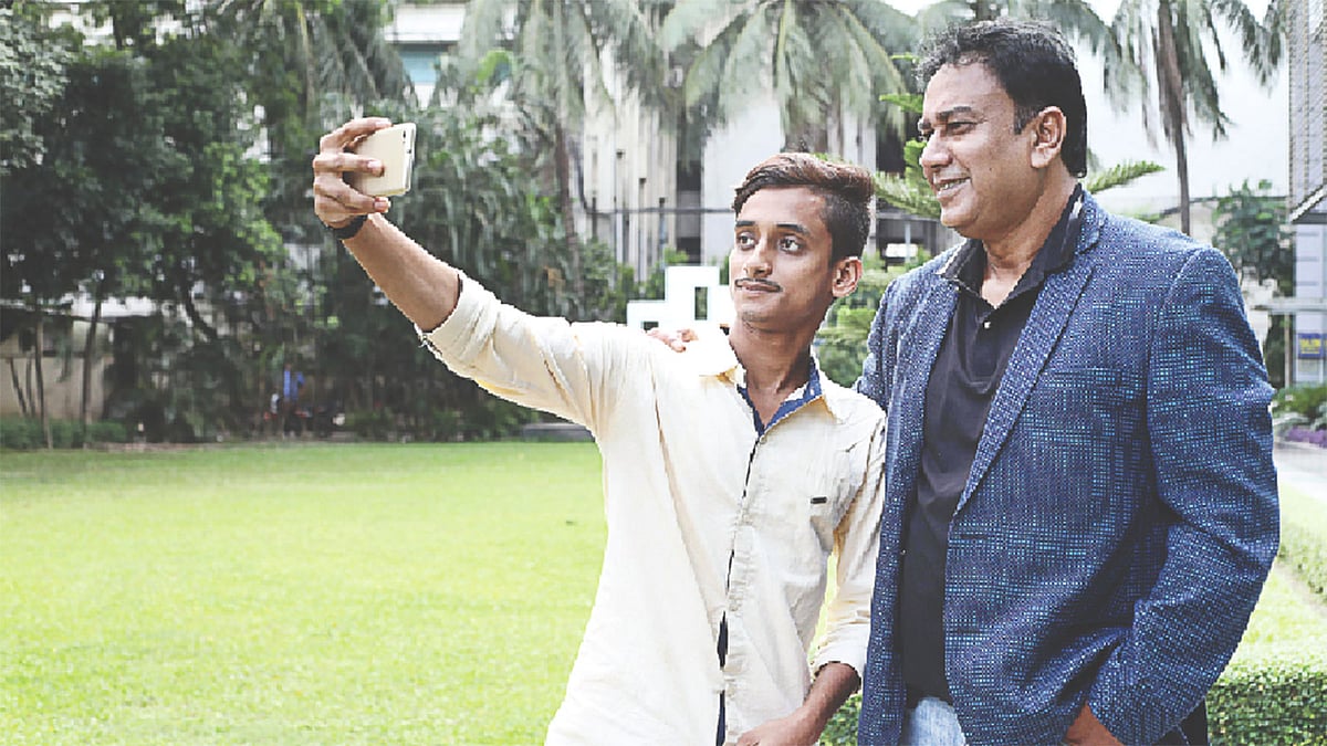 ভক্ত রায়হানের মুঠোফোনে সেলফি তুলছেন জাহিদ হাসান। ছবি: প্রথম আলো