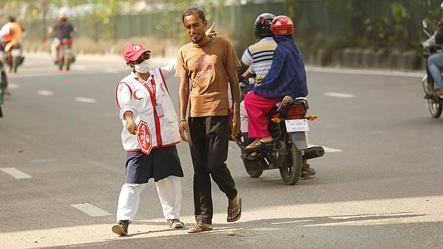 রাজধানীতে ট্রাফিক পুলিশদের সহায়তার জন্য মাসব্যাপী রেড ক্রিসেন্ট সোসাইটির স্বেচ্ছাসেবকেরা রাস্তায় ট্রাফিক সিগন্যাল নিয়ন্ত্রণ ও  পদচারী সেতু ব্যবহারে পথচারীদের সহযোগিতা করছেন। বাংলামোটর, ঢাকা, ৮ সেপ্টেম্বর। ছবি: সুমন ইউসুফ