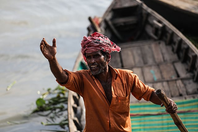 খেয়া পারাপারের জন্য যাত্রীর জন্য হাঁক ছাড়ছেন।