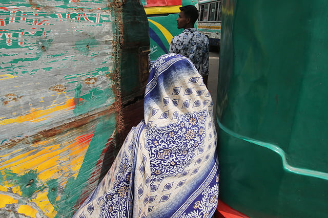 দুই বাসের মাঝখান দিয়ে যাচ্ছেন এক নারী। গুলিস্তান এলাকায় অভ্যন্তরীণ ও দূরপাল্লার অসংখ্য বাস চলাচল করে। ব্যস্ত এই এলাকায় নেই কোনো পদচারী সেতু, তাই ঝুঁকি নিয়েই সড়ক পার হন অনেকেই। গুলিস্তান বাস টার্মিনাল এলাকা, ঢাকা, ১০ সেপ্টেম্বর। ছবি: আবদুস সালাম