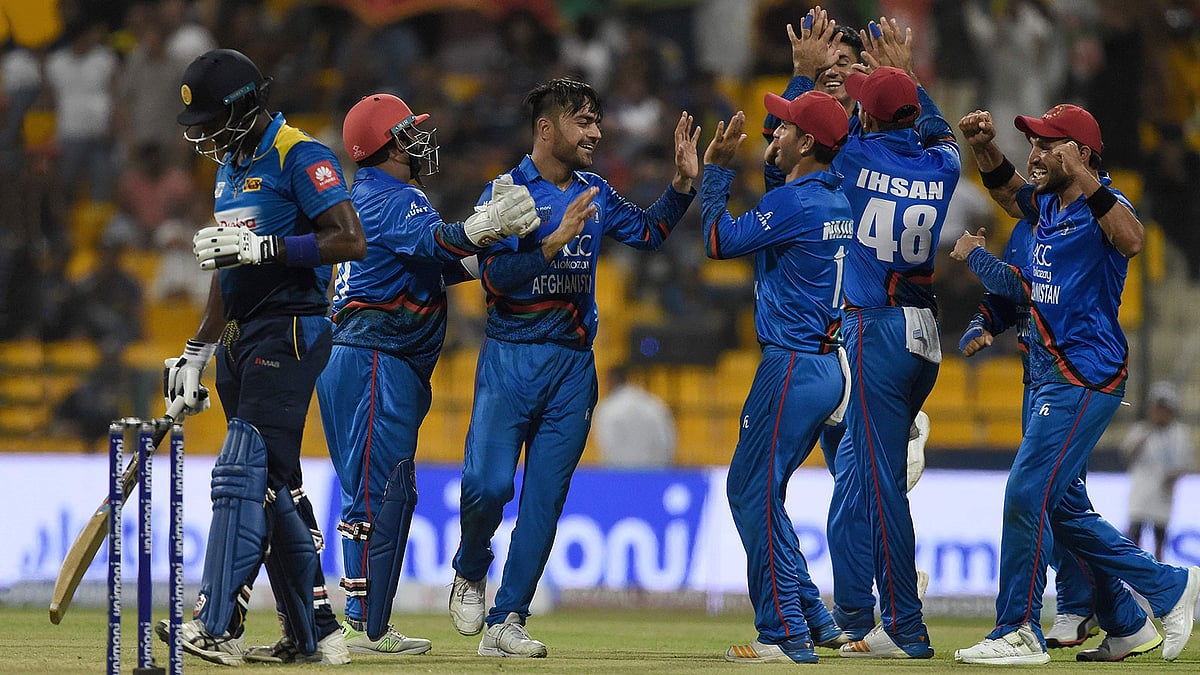 শ্রীলঙ্কান ব্যাটসম্যানরা মাথা নিচু করে মাঠ ছাড়ছেন আর আফগানরা উল্লাসে ফেটে পড়ছেন, এটাই ছিল আজকের নিয়মিত দৃশ্য। ছবি: এএফপি